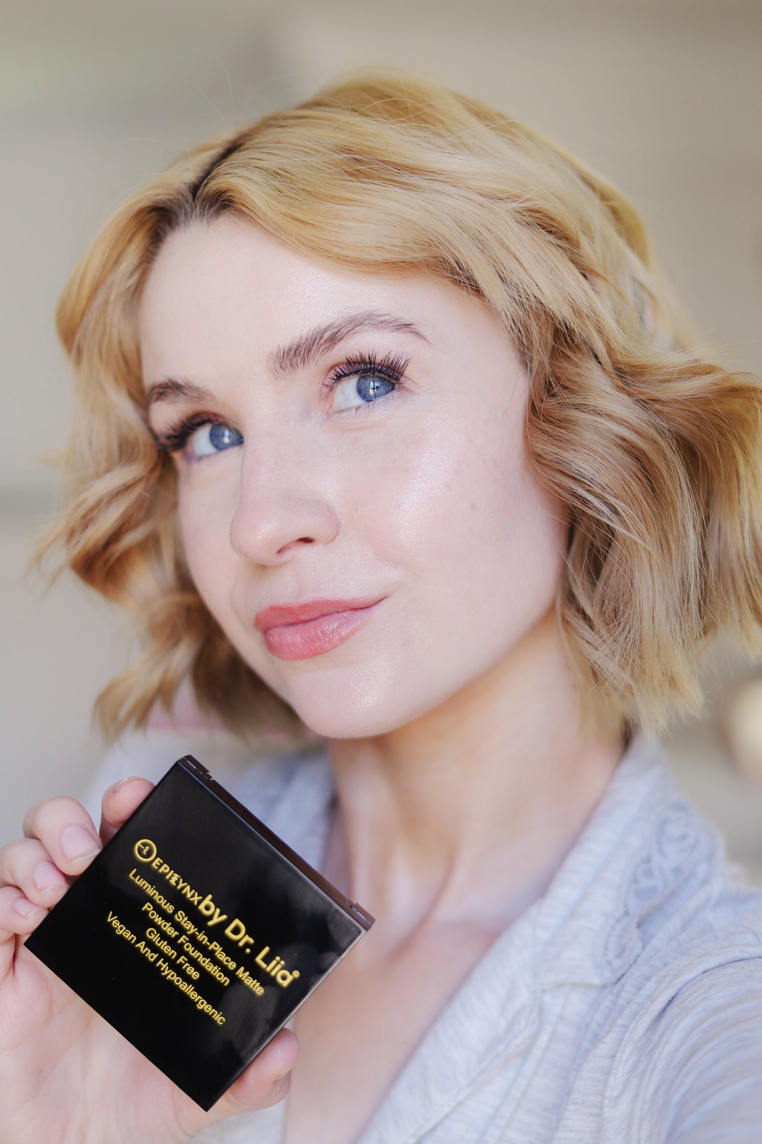 Model holding the EpiLynx gluten-free vegan powder foundation compact