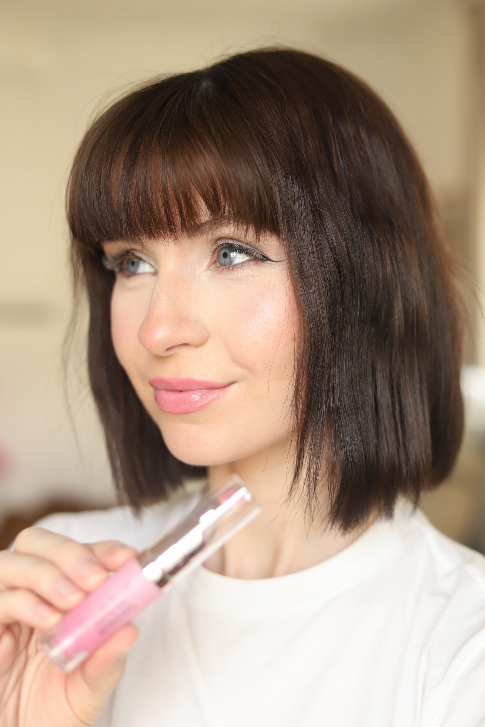 Model holding the EpiLynx Glow Pop gluten-free vegan color-changing lip stain