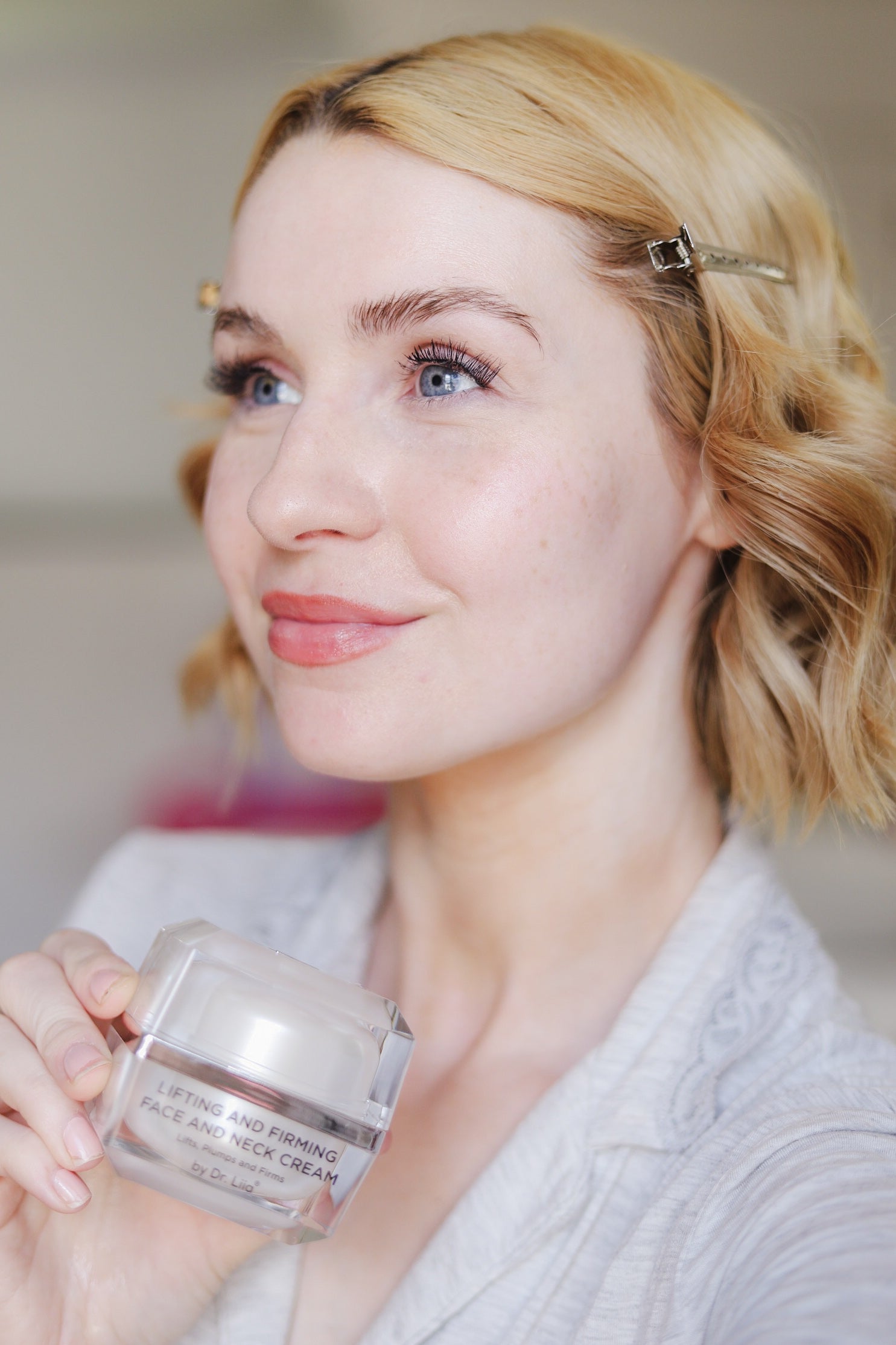 Model holding the EpiLynx gluten-free vegan lifting and firming face and neck cream