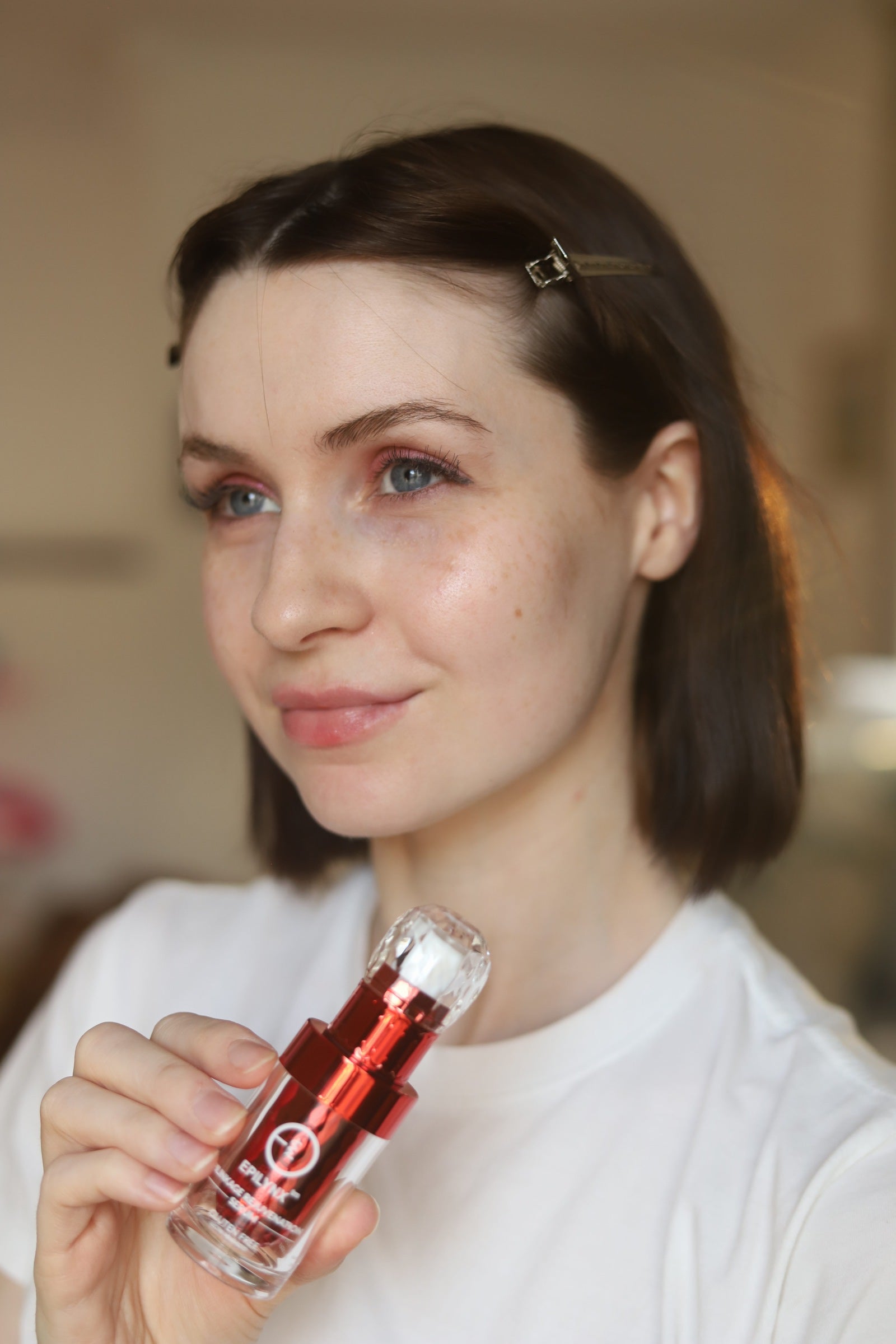 Model holding the EpiLynx gluten-free vegan rejuvenation face serum for mature skin
